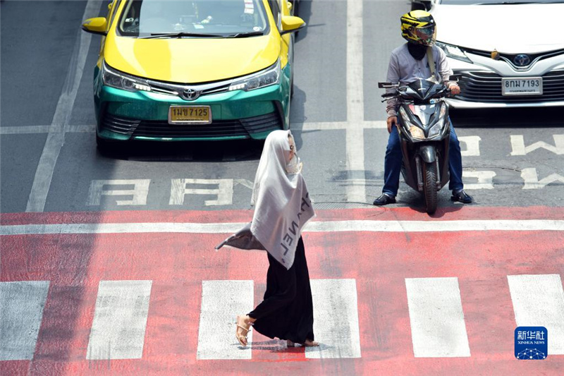5月17日，行人在泰國曼谷街頭用圍巾遮陽。新華社發(fā)（拉亨攝）