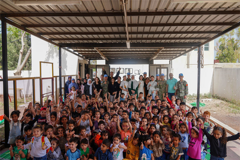 當(dāng)?shù)貢r(shí)間5月30日，黎巴嫩南部庫(kù)雷拉公立小學(xué)，“六一”國(guó)際兒童節(jié)前夕，中國(guó)第21批赴黎維和多功能工兵分隊(duì)官兵看望慰問學(xué)校師生，并開展文化交流活動(dòng)，圖為我維和官兵同師生合影。李竹林?jǐn)z