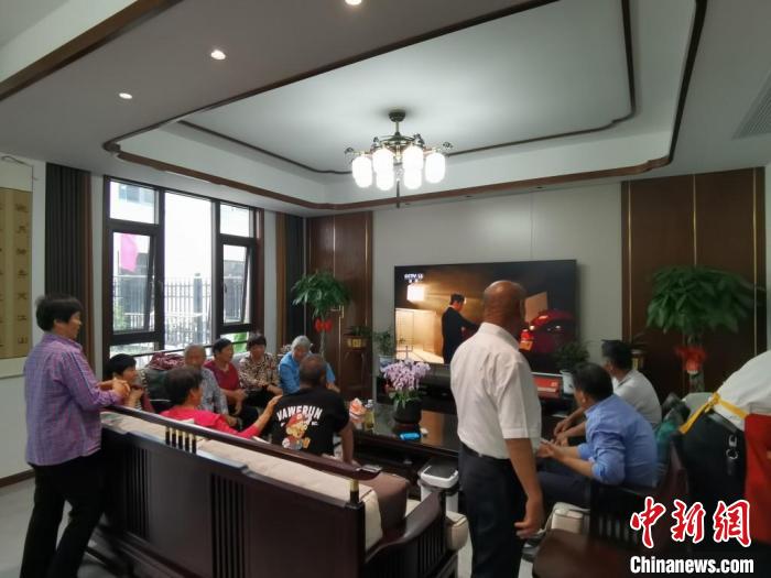 親友們集中在費(fèi)俊龍家中觀看返程的視頻?！＄娚?攝