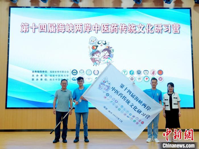 共青團福建省委副書記吳雪(右一)、福建中醫(yī)藥大學黨委副書記林羽(左一)為兩岸學生代表頒授營旗?！≡S燁婷 攝