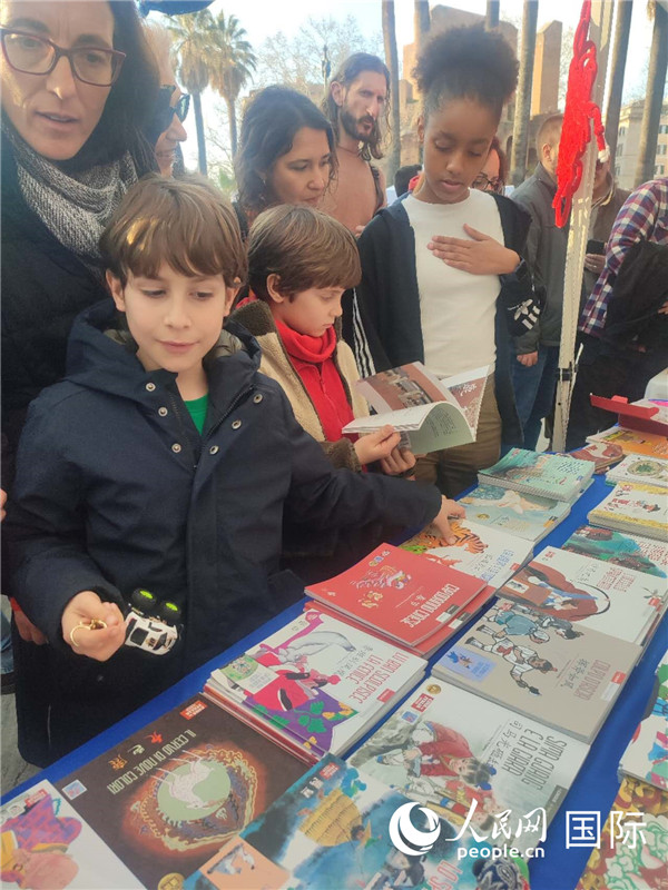 印刷精美的中國傳統(tǒng)文化叢書吸引了小游客的注意。人民網(wǎng)記者鄭彬攝