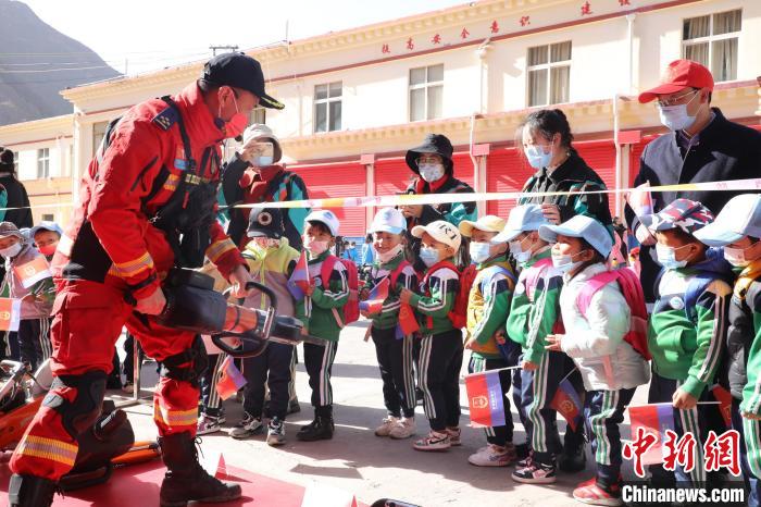 圖為消防指戰(zhàn)員為學(xué)生講解、演示先進(jìn)救援裝備?！≮w琳 攝