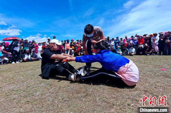 圖為當(dāng)?shù)孛癖娺M(jìn)行蹬棍比賽?！±铍h 攝