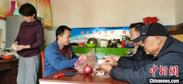 圖為扶貧路上“臨時(shí)一家人”準(zhǔn)備午餐?！∥航ㄜ?攝