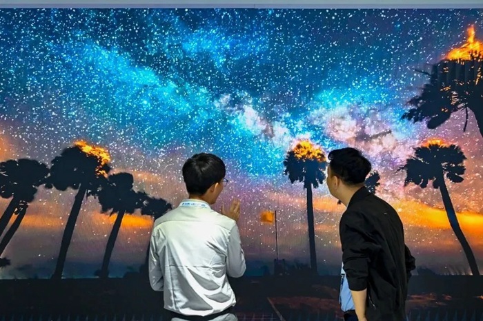 長(zhǎng)春光博會(huì)希達(dá)電子展區(qū)，一位工作人員正在給一位觀眾講解。（長(zhǎng)春新區(qū)供圖）