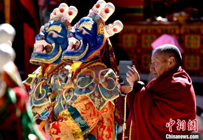 2月19日，正在拍攝跳神活動的僧人?！±盍?攝